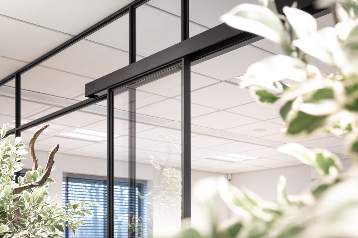 Bovenrail schuifdeur in kantoor achter bloemen